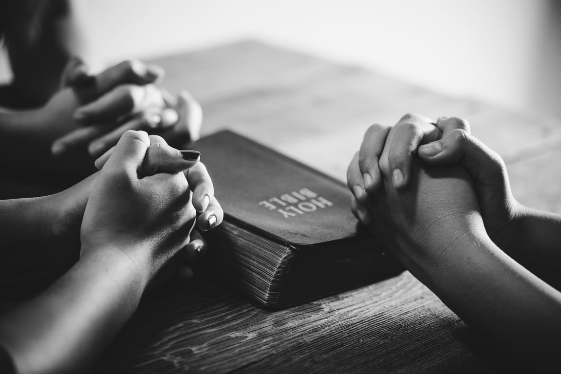 Black and White Photo of People Praying Together
